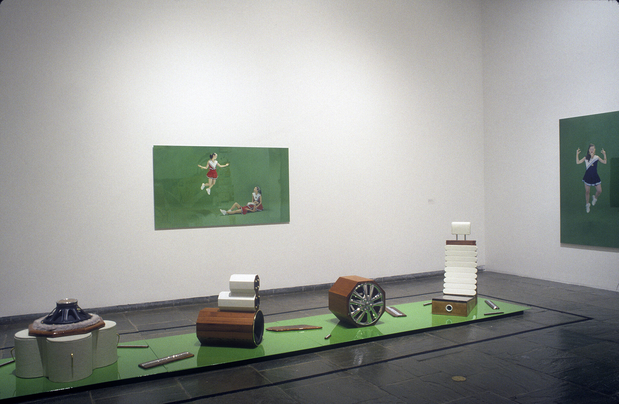 A gallery filled with various works of art, including a photos of cheerleaders and sculptures.