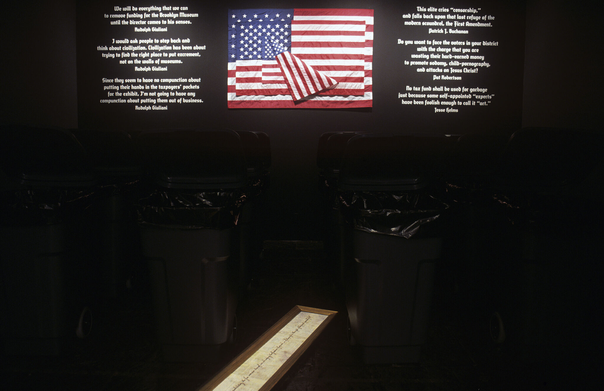 An American flag and text on a dark wall.