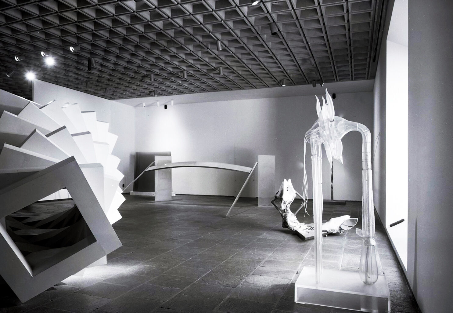 Black-and-white photograph of works of art in a gallery.