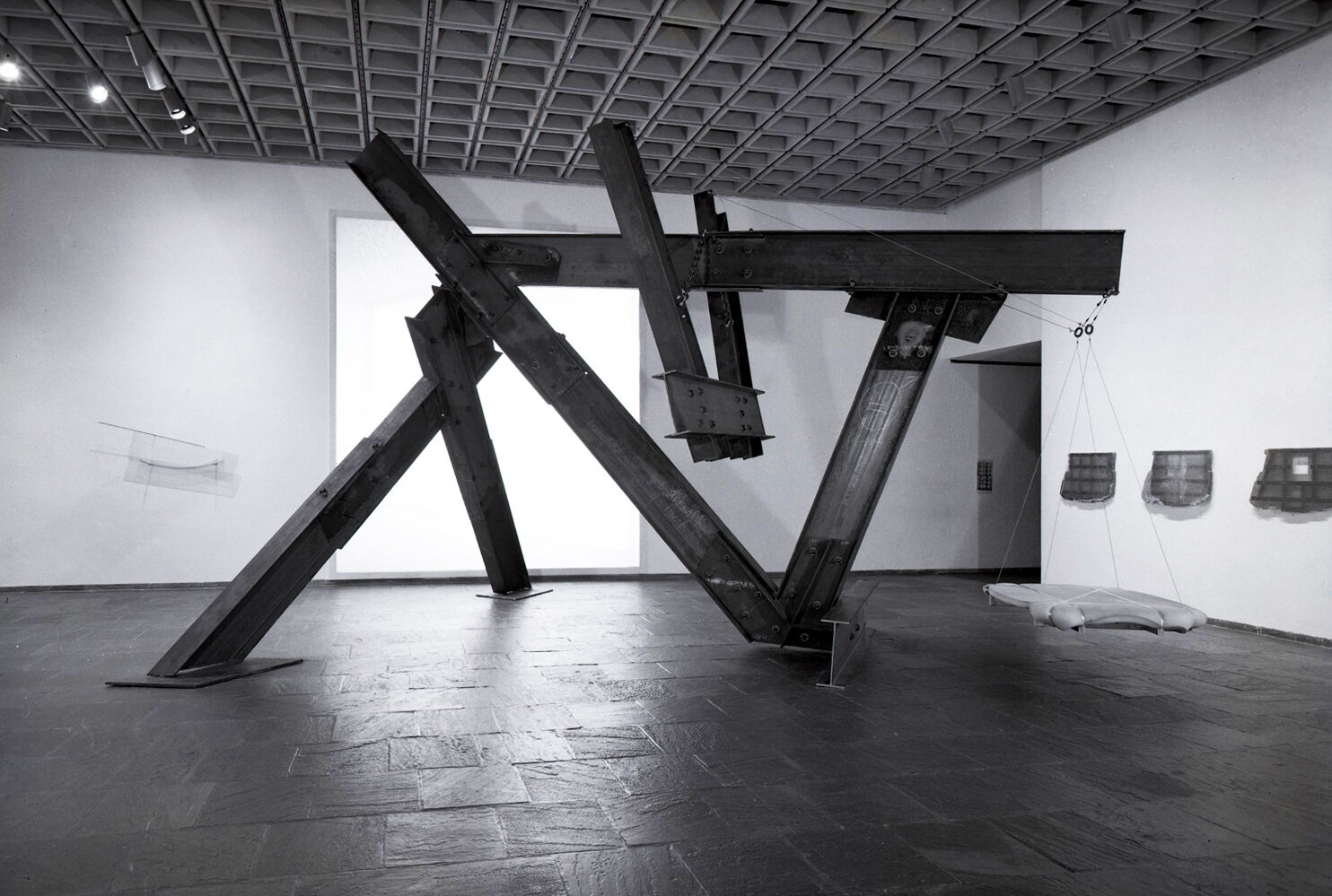 Black-and-white photograph of works of art in a gallery.