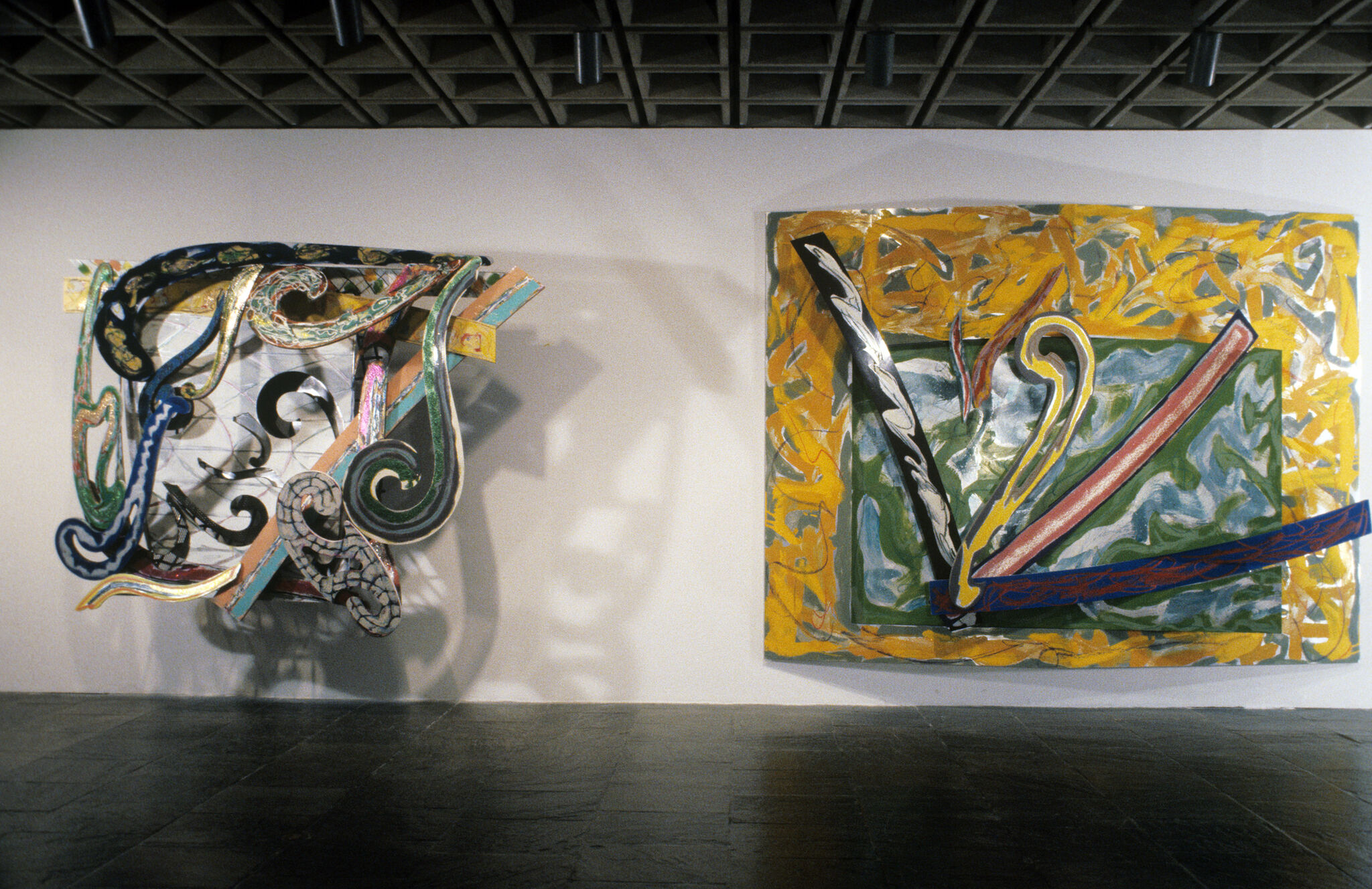 Two paintings hanging in a gallery.