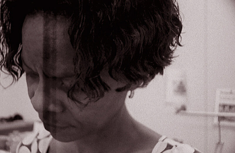 A still shot from a video of a woman looking down. 