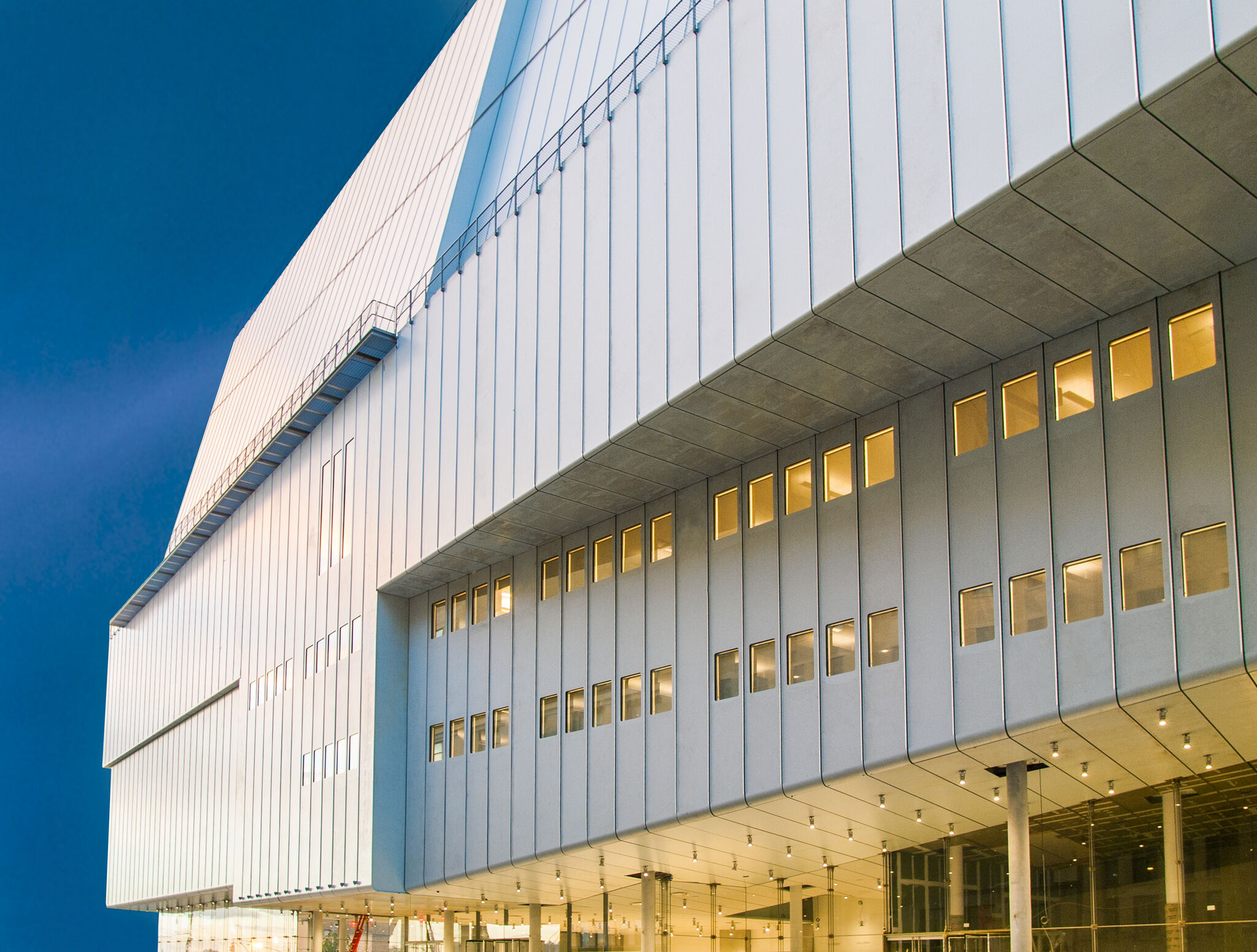 The facade of the Whitney Museum against a blue sky.