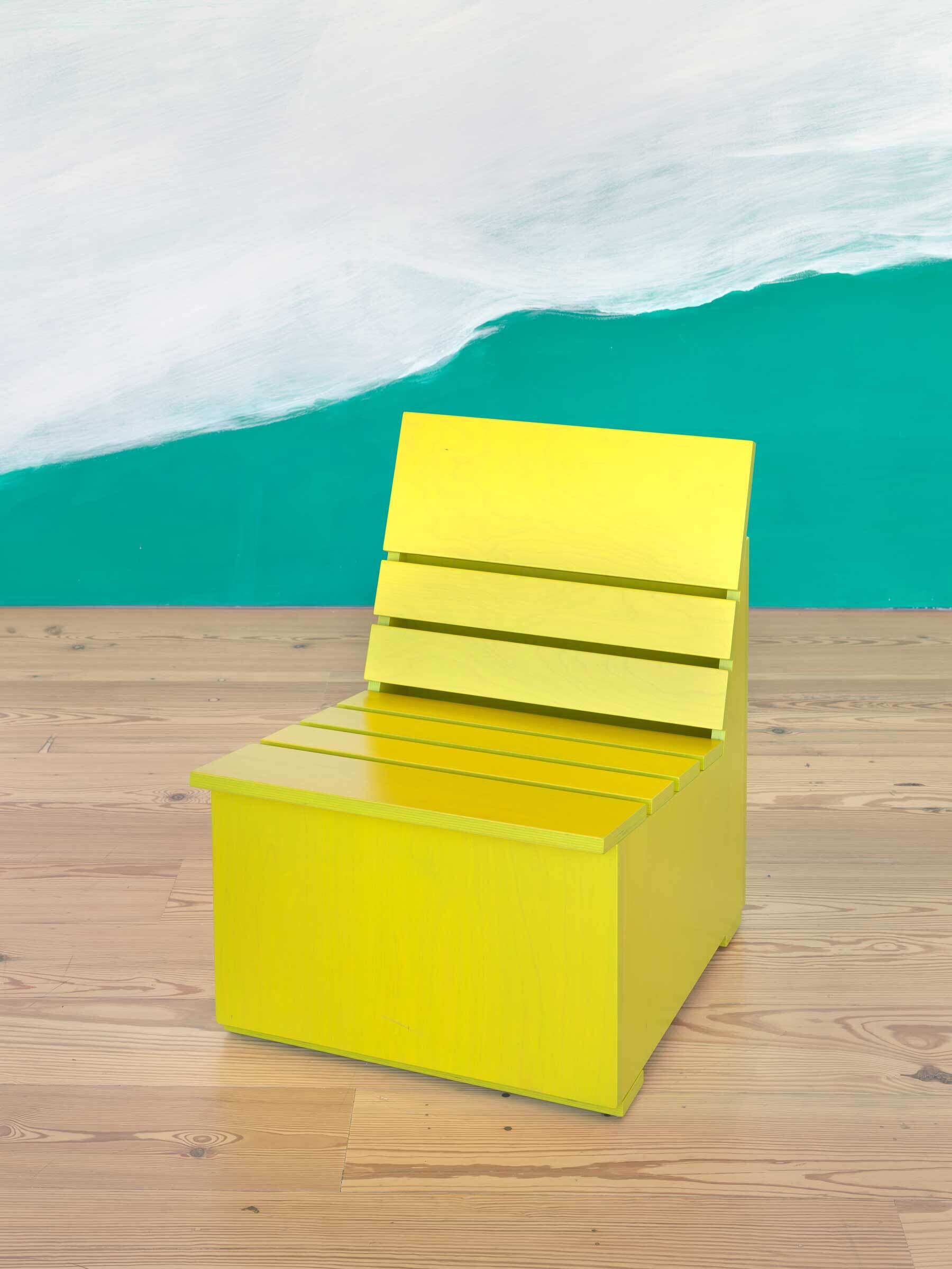 Bright yellow wooden chair with a slatted back and seat, placed on a light wooden floor.