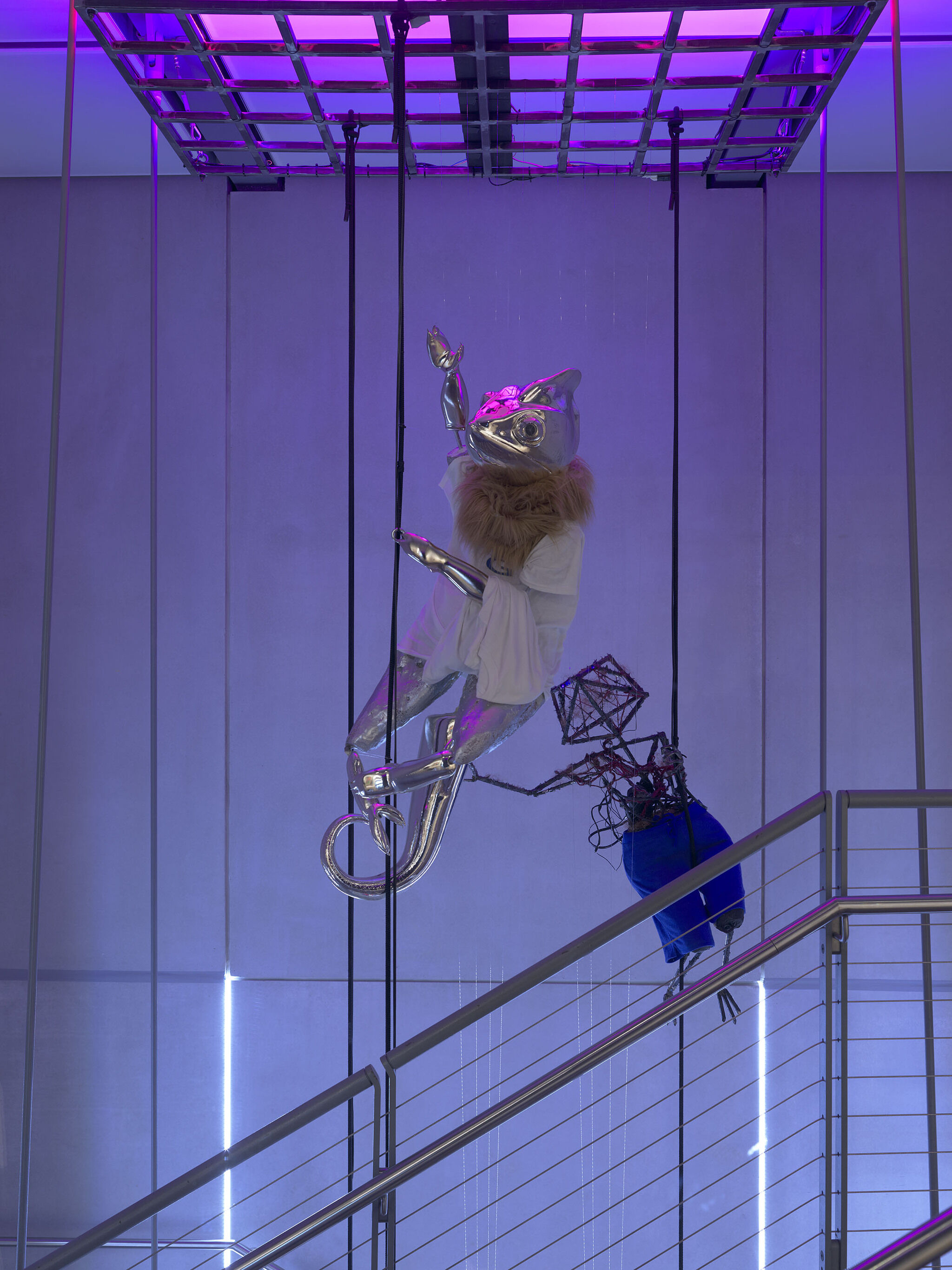 A sculpture displayed in purple and blue lighting.