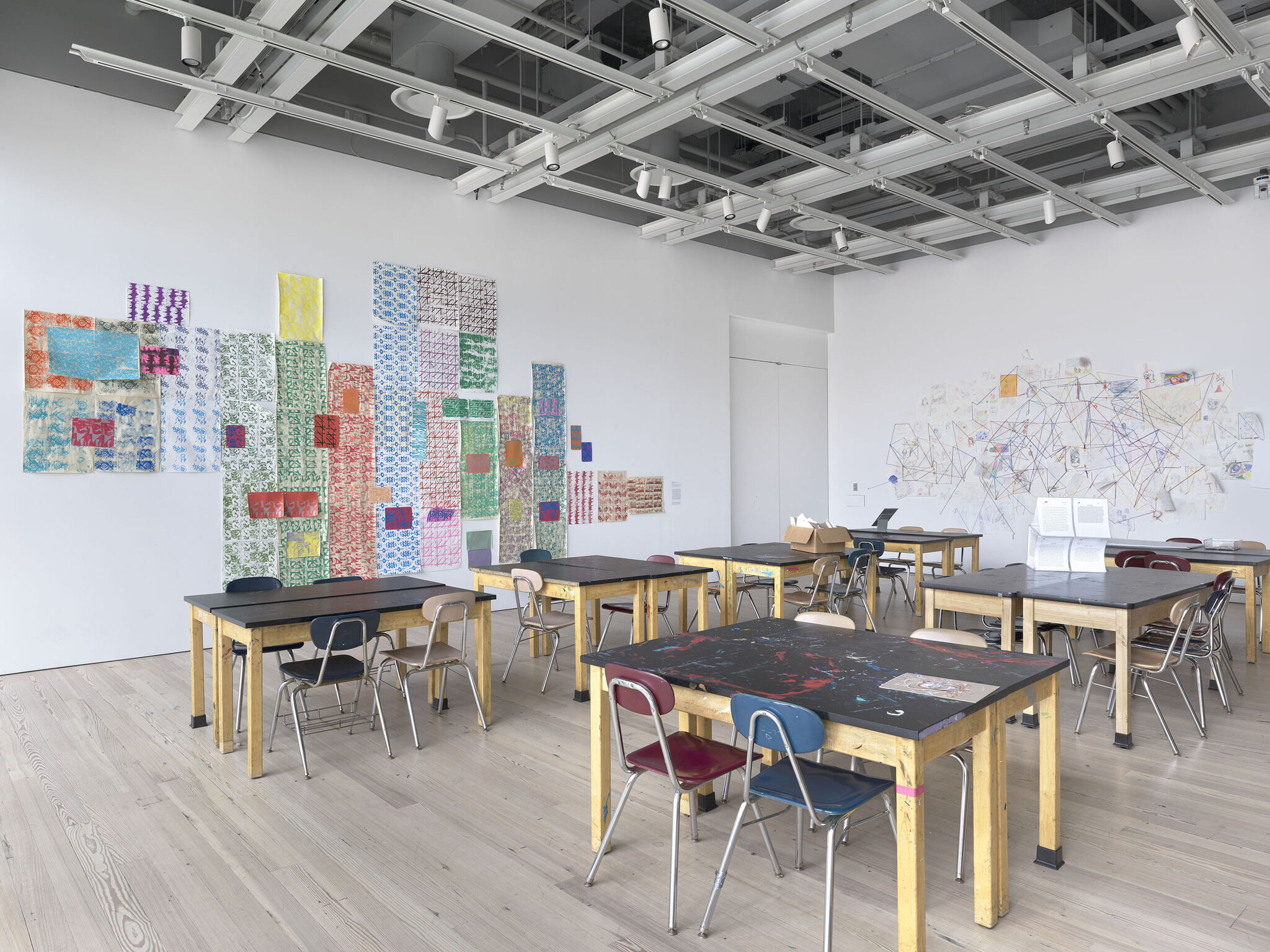An installation view of a classroom with art.